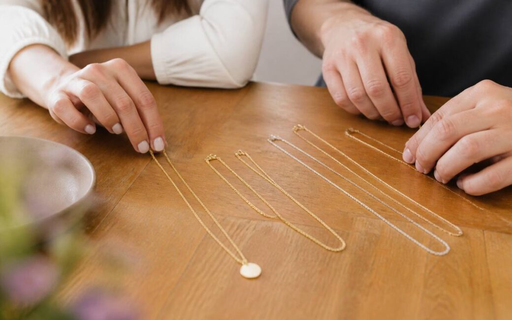 Close-up van verschillende halskettingen op een houten tafel onder natuurlijk licht